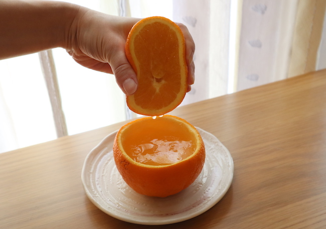 オレンジゼリーに果汁を搾る様子