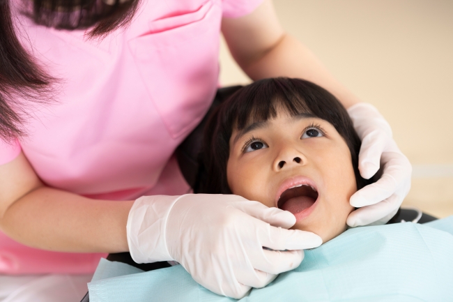 歯医者の診察を受ける女児