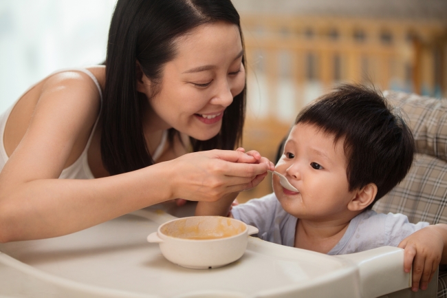 男の子にご飯を与える母親