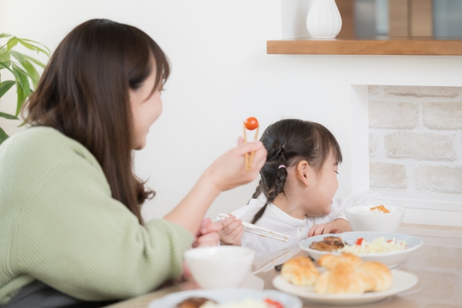 子どもに食べさせるお母さん