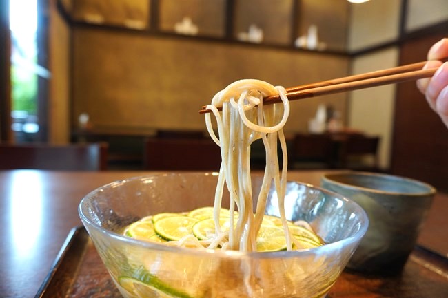 箸で持ち上げた冷やしかけすだち蕎麦