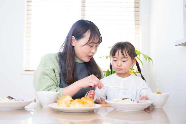 子どもに食べさせるお母さん