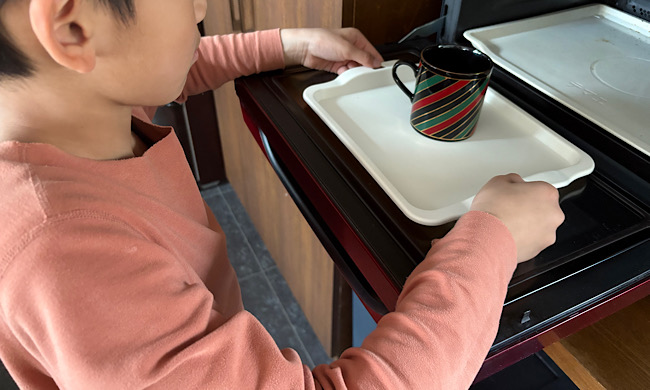 子どもが電子レンジでら使えるトレーを持つ