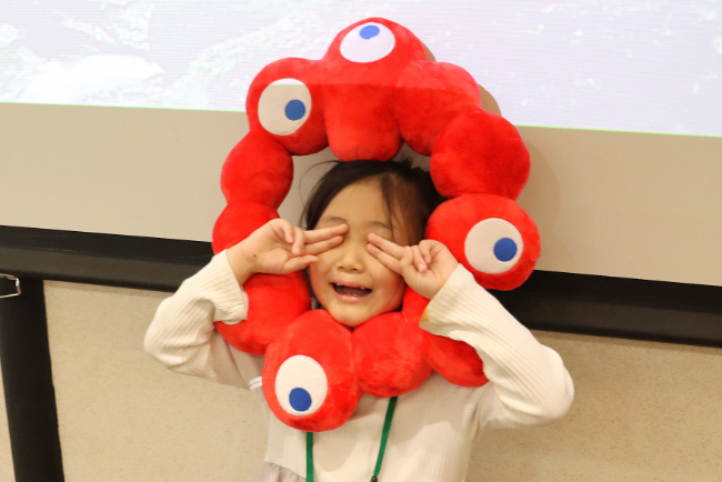 ミャクミャクの帽子をかぶる女の子