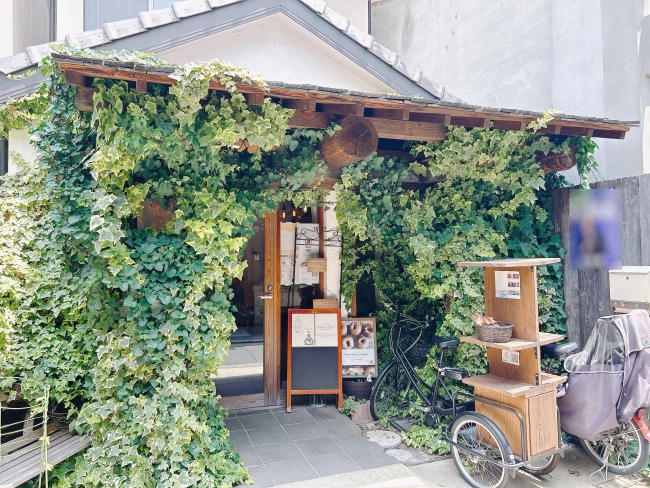 緑の蔦に覆われたお店の入り口