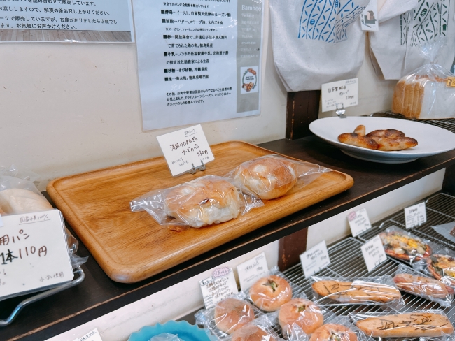 棚に並ぶパンと原材料についてのこだわりが書かれたポスター