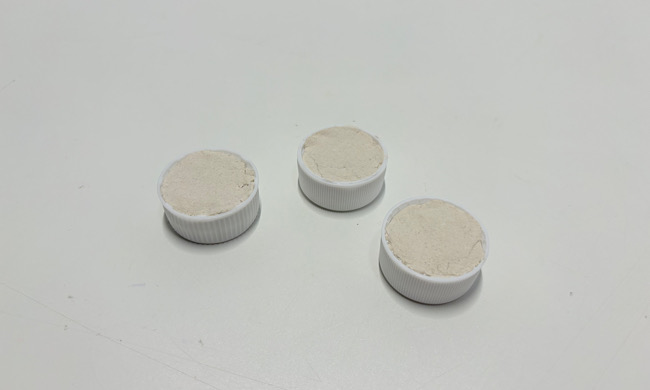 ペットボトルキャップの中に詰められた紙粘土