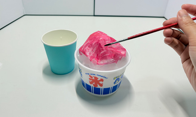 水性ペンの色が染み込んだ花紙に筆で水を含ませる