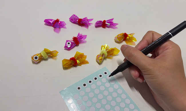 目玉のシールを貼り付けられた金魚