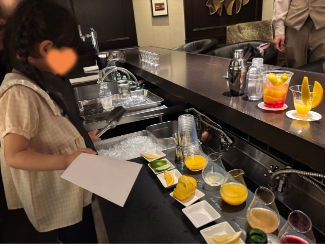 バーカウンターの中で材料を見ている子ども