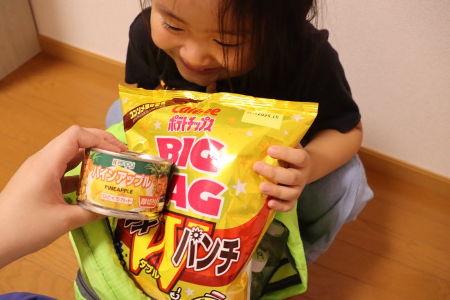防災リュックに荷物を詰める親子