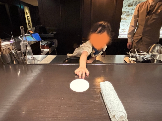 コースターをお客様へ渡す子ども