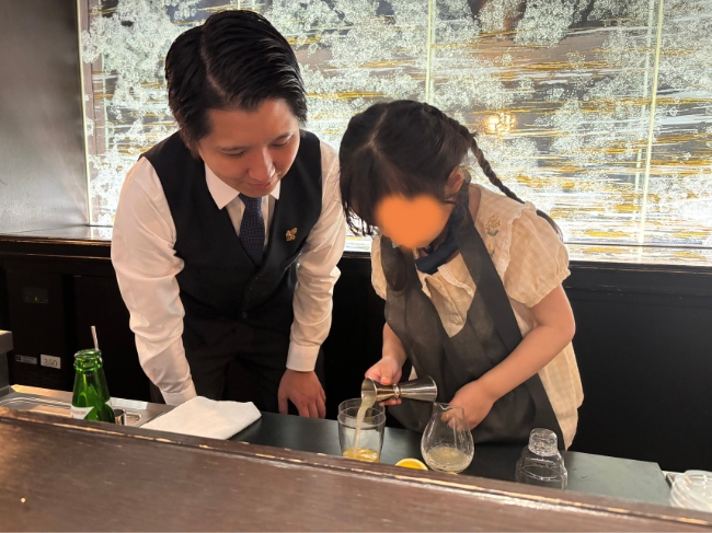 カクテルの材料を入れる子ども