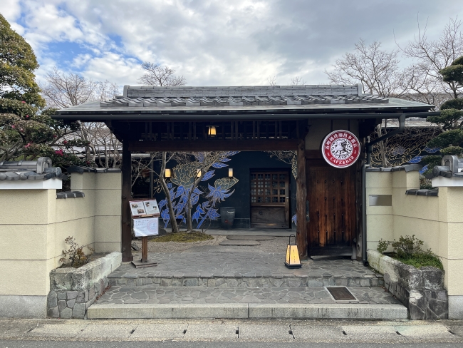 「eXcafe京都嵐山本店」の入り口にある木の門