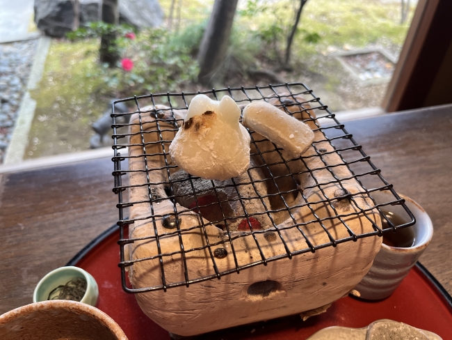七輪の網の上にのった餅と生麩