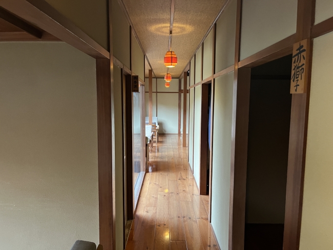 長く続く木の廊下と落ち着いた照明の店内