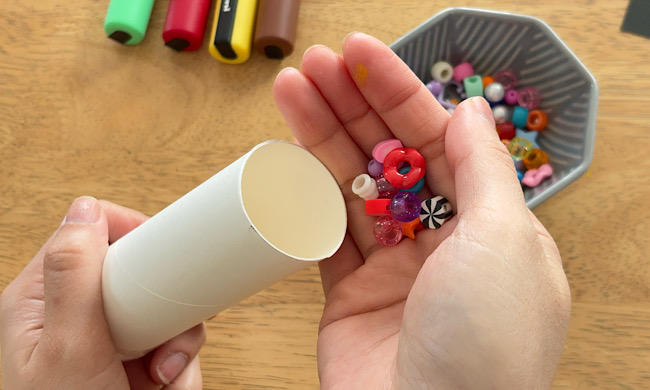 トイレットペーパーの芯にビーズをいれている様子