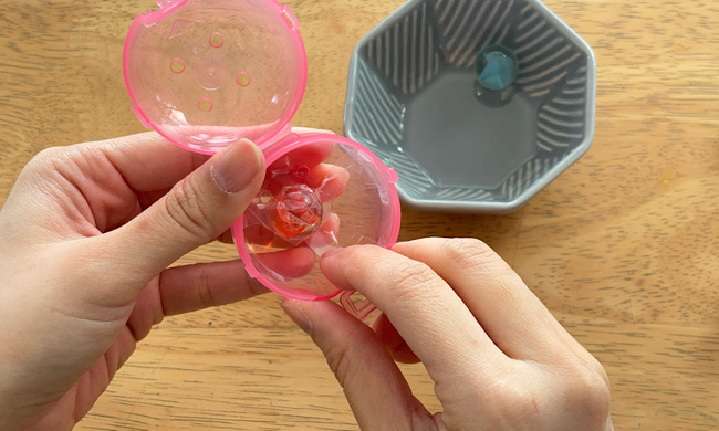 カプセルトイの底にビー玉を貼りつける工程