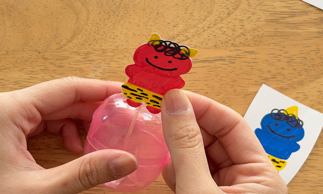 カプセルに鬼のイラストを貼りつける工程