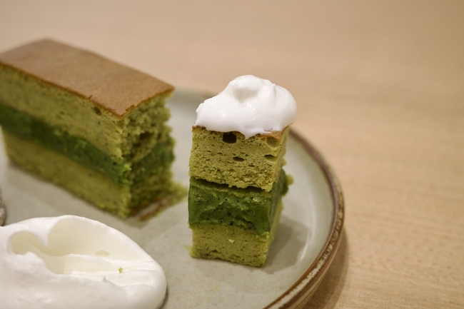 お皿の上にのった抹茶ケーキと生クリーム