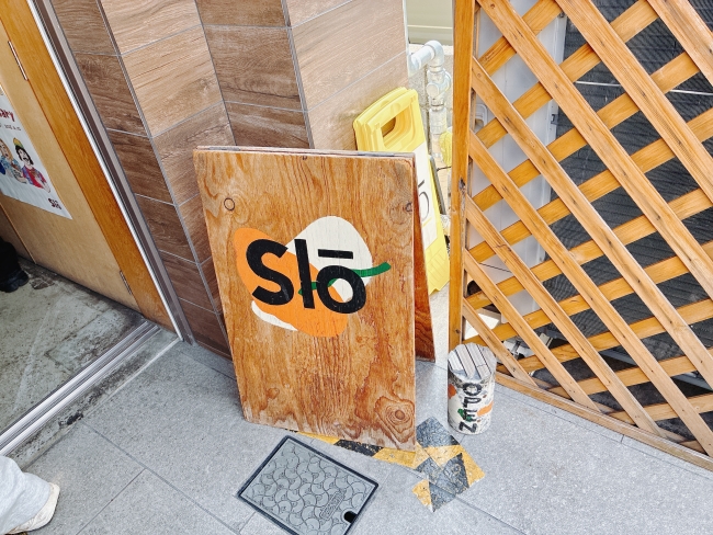 お店のロゴが描かれた木の看板